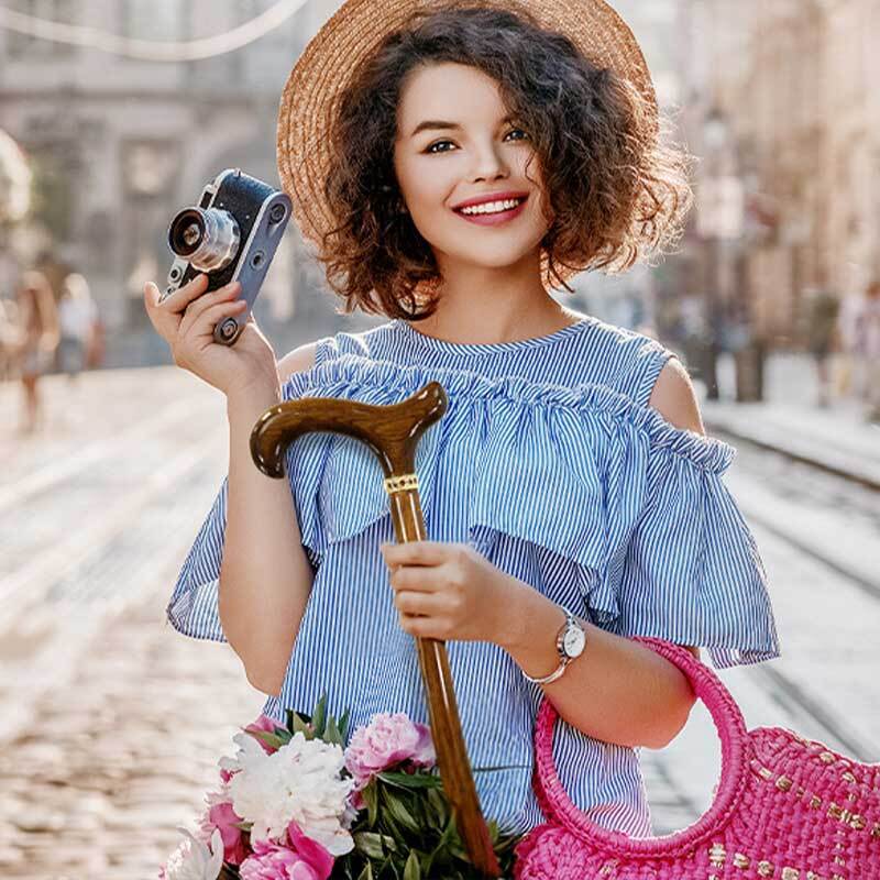 a woman in a blue dress holding a wooden walking stick